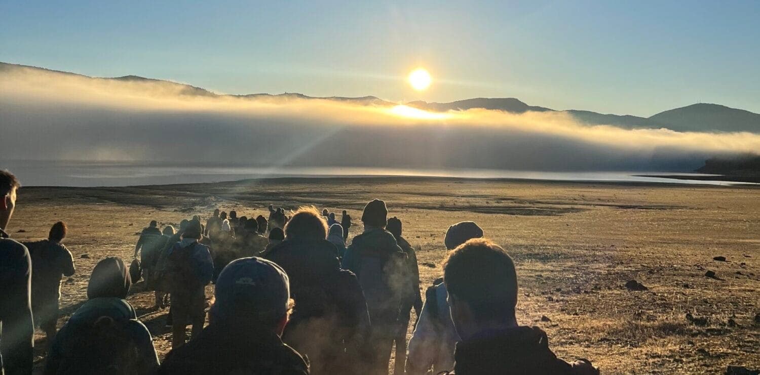 Justin and a group watching the sunrise over a foggy valley